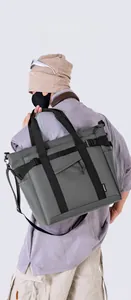 Detail of grey nylon tote bag showing adjustable side buckles and durable black handles