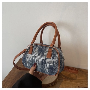 Detail of blue denim Boston bag with sequin stripes and brown leather handles