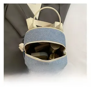 Internal view of denim backpack showing capacity for cosmetics and accessories
