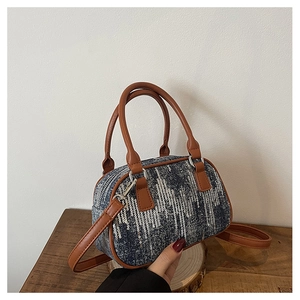 Detail of denim Boston bag featuring silver sequins and premium brown leather straps