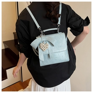 Detail of light blue pleated PU leather backpack with bow and heart pearl pendant
