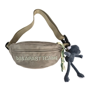 Minimalist grey nylon chest bag with letter embroidery and frog pendant on white background