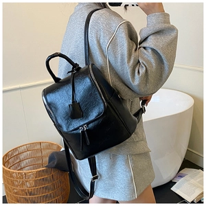 Chic black leather backpack with silver zippers shown in a modern lifestyle setting