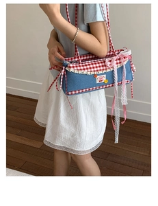 Detail of blue denim handbag with red plaid trim, lace edges and pink ribbon bow