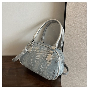 Detail of blue denim Boston bag with silver sequins and metallic leather handles