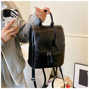 Fashionable black glossy bucket backpack with silver hardware in a lifestyle mirror selfie