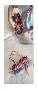 Detailed close-up of blue denim handbag with red plaid trim and white lace edges