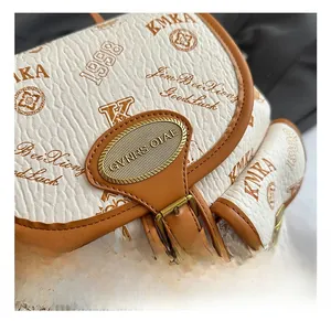 Detail of white lychee leather bucket bag with retro prints and golden metal lock