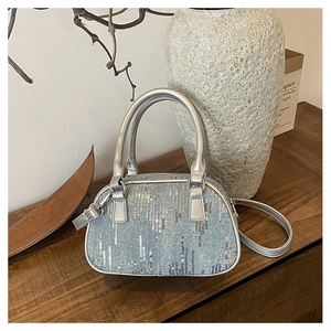 Detailed view of mini light blue denim bag with sparkling silver sequins and leather strap