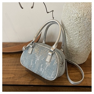 Detail of mini denim boston bag with silver sequins and metallic top handles