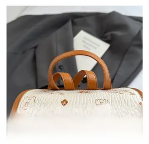 Detailed macro view of brown leather handle and cartoon bear print on bucket bag