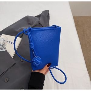 Detail der königsblauen Handy-Tasche mit Litschimuster, Knoten und Kugelanhänger