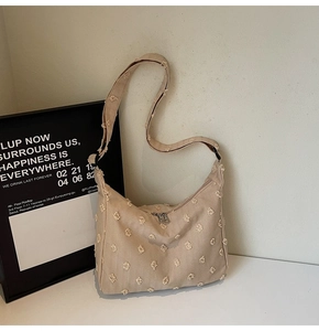 Detailed view of beige tufted tote bag showing soft textured fabric and curved zipper top