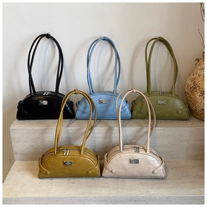Detail view of stylish crocodile pattern shoulder bags in five assorted colors on stone steps