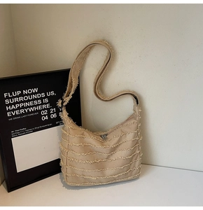 Detail of light camel canvas tote with fringe texture and metal zipper closure