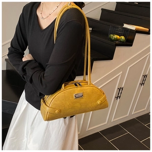 Detail shot of bright yellow crocodile embossed underarm bag with silver hardware logo