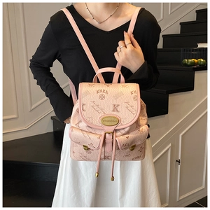 Detail of light pink bucket bag with monogram pattern and cute bear motif for women