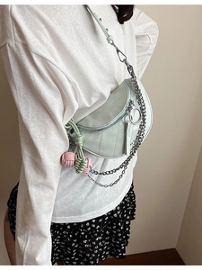Pale green saddle crossbody bag with silver chain strap and colorful woven charms