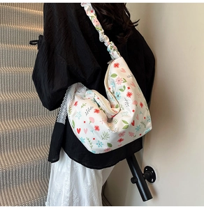 Detail of floral Oxford fabric shoulder bag with lace trim and ruched strap on a model