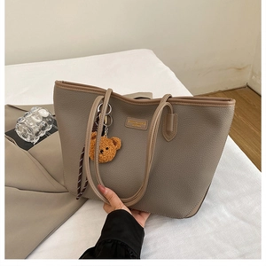 Dettaglio della borsa tote in pelle martellata talpa con un simpatico orsetto