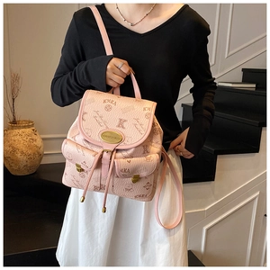Close-up of pink pebbled leather backpack with unique monogram and gold logo plaque