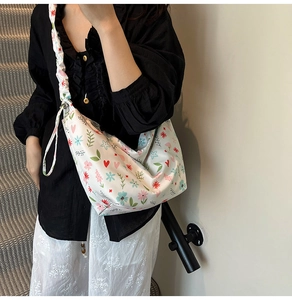 Close-up of a floral Oxford cloth crossbody bag with trendy ruffled cloud shoulder strap