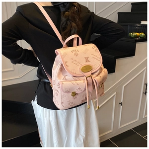Detailed view of pink printed leather backpack with drawstring and flap on black stairs