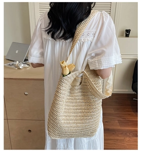 Close-up of beige crochet straw tote bag showing hollow-out knit and large capacity
