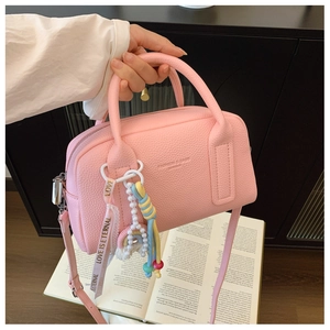Detail of pink Boston bag showing leather texture and decorative love pearl charms