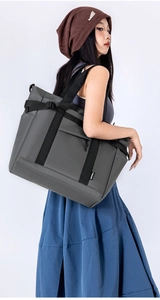 Detail view of large dark grey crossbody tote bag showing nylon texture and side buckle