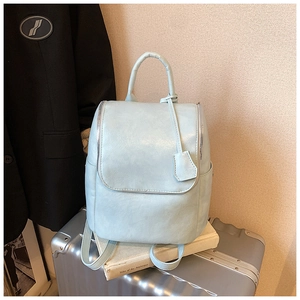 Detailed view of light blue PU leather backpack with top handle and flip-top closure
