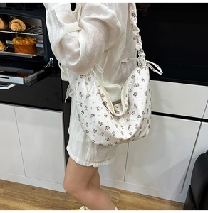 Detail of floral Oxford fabric bag with pleated cloud strap and red rose patterns