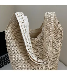 Detailed close-up of woven paper straw texture and fabric lining of this beach tote bag