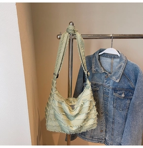 Detail of light green canvas tote bag featuring unique layered fringe and tassel design
