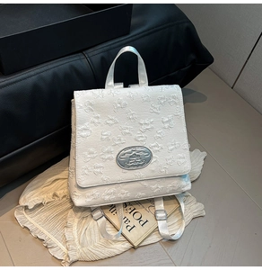 Detailansicht des weißen Rucksacks mit Wolkentextur und ovalem silbernem MIKA-Logo