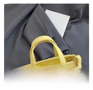 Detail of yellow bucket bag with lychee grain texture and comfortable handle
