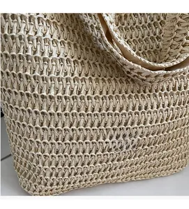 Close-up of natural beige straw tote featuring intricate handmade weaving and handle detail