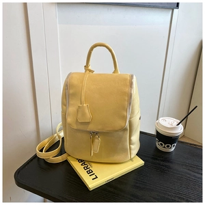 Detail of light yellow PU leather backpack featuring fine texture and metal zipper