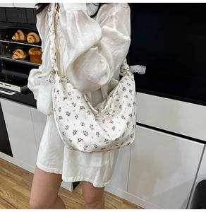 Detail shot of Oxford cloth bag featuring floral patterns and white lace shoulder straps