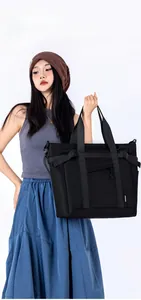 Detail of multi-functional black shoulder bag with wide handles and NONGKA side label