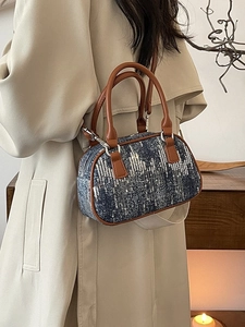 Fashionable sequined denim pillow bag with leather handles shown in a chic urban setting
