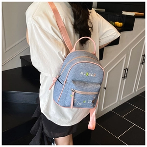 Detail of blue denim backpack with pink leather trim and MYBAOB embroidery for women