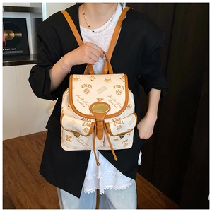 Macro detail of cream vintage backpack featuring bear patterns and dual front flap pockets