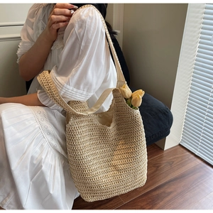 Detail of hand-woven straw tote bag with crochet texture and natural beige finish