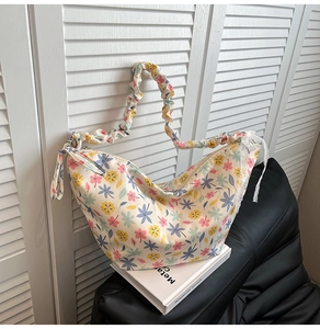 Detail of floral Oxford bag with ruffled cloud strap and white lace bow decoration