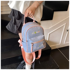 Detail of blue denim backpack with pink piping and MYBAOB heart embroidery
