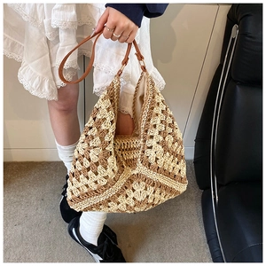 Detail of hand-woven straw tote bag featuring a khaki checkerboard pattern and leather strap