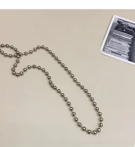 Detailed view of a silver bead chain strap with a polished metallic finish for small handbags