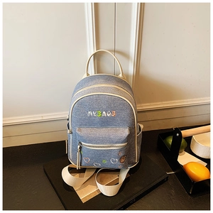 Detail of color-block denim backpack featuring cute MY BAG embroidery and bear patterns