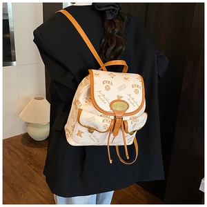 Detail of cream backpack with KMKA bear monogram print and brown leather trim accents